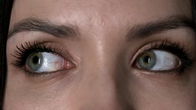 Macro of two green female eyes moving around