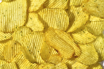 Corrugated potato chips with green onions, close-up food background, texture