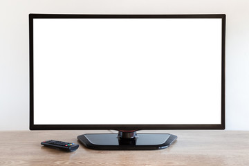Black tv with remote control on wooden table at gray wall. Empty place for text, photo image on...