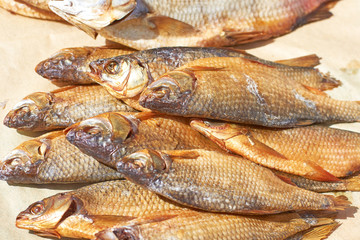 Dried fish with salted scales on packaging paper, close-up