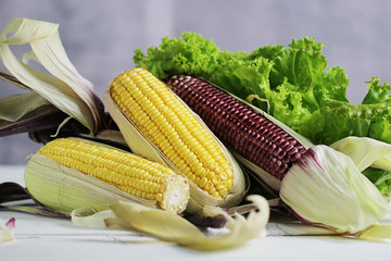 Fresh corn on white wooden table.