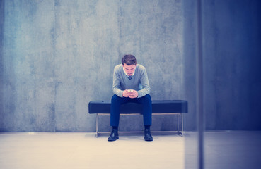 businessman using smart phone while sitting on the bench