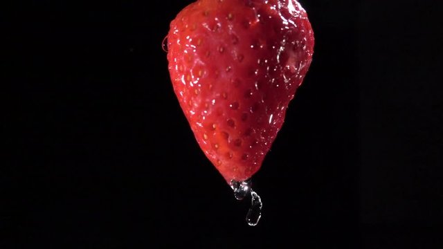 Slowmotion video of strawberry and water drops