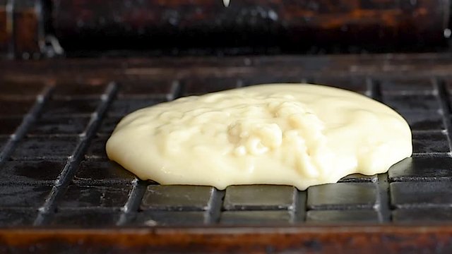 Preparation of wafers from fresh dough in a waffle maker in daylight. Waffles. Cooking fresh hot waffles in a waffle maker