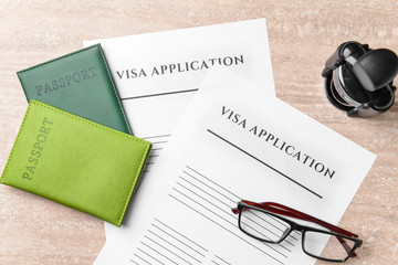 Visa application forms, passports, stamp and glasses on table. Concept of immigration