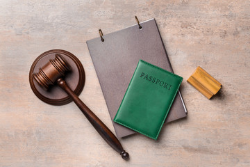 Judge's gavel, notebook, stamp and passport on table. Immigration law concept