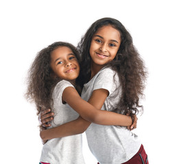 Cute hugging African-American girls on white background