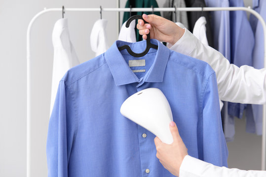 Woman Steaming Clothes At Dry-cleaner's