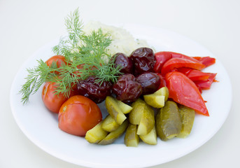 marinated sliced vegetables on a plate, cabbage, cucumbers, peppers and tomatoes, restaurant feed