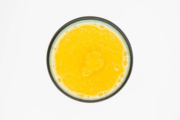 Pumpkin smoothie in a blue glass сup with a blue tube, top view