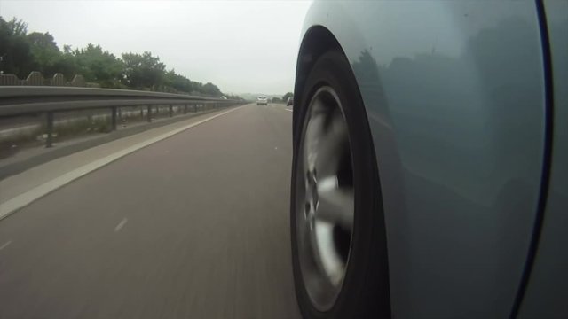 A highly stylized clip of a car speeding down the highway on the German autobahn. Highway wheel ungrade.d