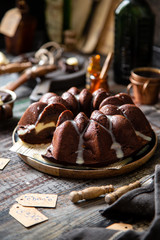 Delicious homemade chocolate bundt cake on wooden plate stands on rustic table