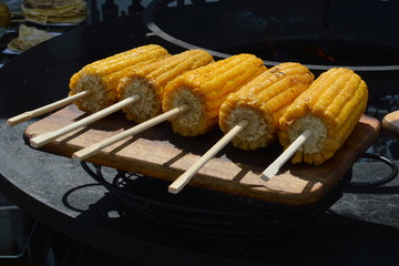 Grilled corn on wooden skewers