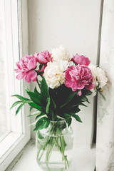 Beautiful pink and white peonies bouquet at rustic old wooden window. Floral decor and arrangement. Gathering flowers. Rural still life, countryside. Happy mothers day
