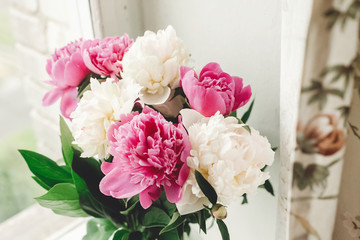 Beautiful pink and white peonies bouquet at rustic old wooden window. Floral decor and arrangement. Gathering flowers. Rural still life, countryside. Happy mothers day