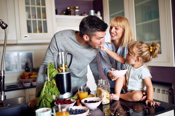 Child with parents having fun during breakfast