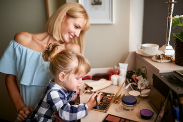 Obraz na płótnie Canvas Little girl with mom having fun with makeup