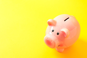 Happy piggy bank on yellow background, space for text. Finance, saving money