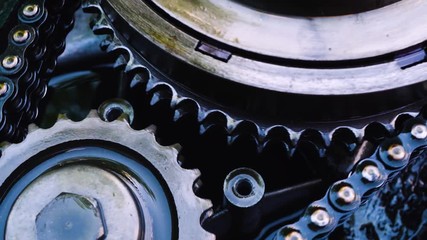 The device mechanical device inside close up. Shine of oil on the surface of dark steel. Proper operation of oiled gears and rollers.