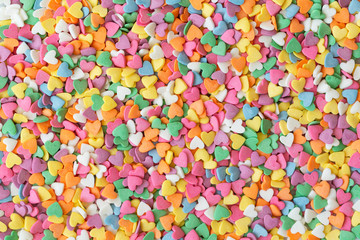 Fototapeta na wymiar Sugar sprinkle dots hearts, decoration for cake and bakery. Colorful sugar sprinkles scattered on white background 