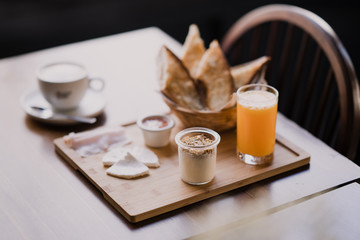 Tabla con desayuno saludable con jamon, queso fresco, tostadas, tomate y zumo de naranja natural