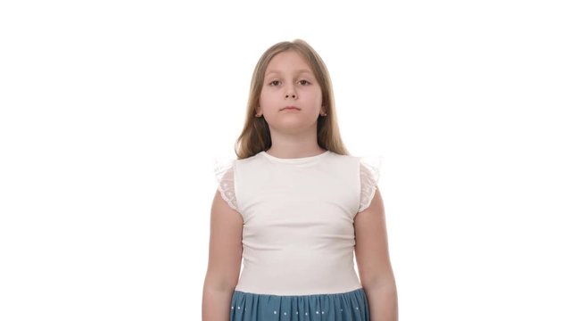 Video portrait of emotional young attractive girl looks surprisedly at camera isolated on white background. Child being shocked to hear awful news. Studio shot of child emotions and gestures in 4K.