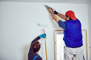 Two handymen working together on a house renovation.