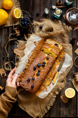 Overhead shot of homemade tasty lemon baked cake with blueberries on paper and sackcloth 