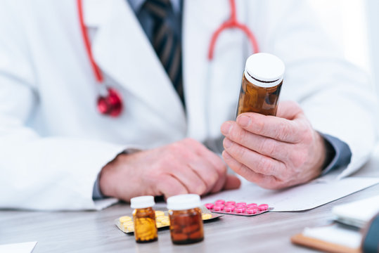 Doctor looking at a bottle of pills