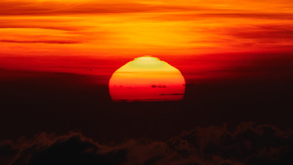 Sunrise / sunset over the clouds and horizon in golden colors.