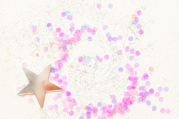 Confetti and silver stars on a white background, festive concept.