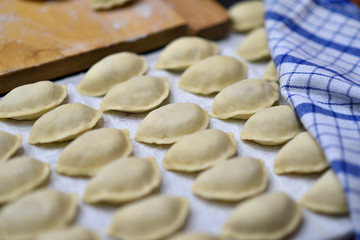 Fototapeta na wymiar Lots of raw dumplings, pierogi, making dumplings, cooking
