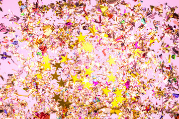 Colorful celebration background with confetti,stars, fireworks and decoration on pink background.