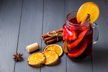 Mulled wine and spices on gray wooden background. Selective focus.