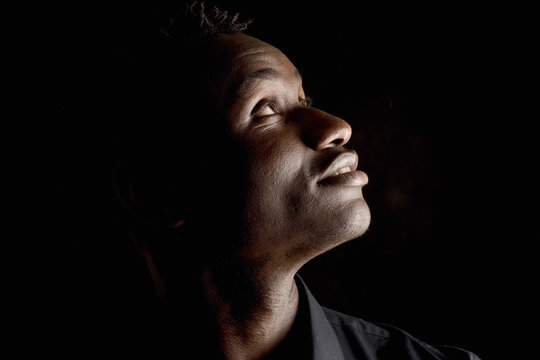 Portrait Of A African Man Look Up On Black Background