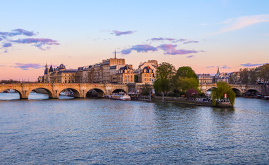Obraz premium The oldest bridge ( Pont Neuf ) across Seine River and historic buildings of Paris France at sunset. April 2019