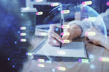 Multi exposure of writing hands on background with data solution hologram. Technology concept.