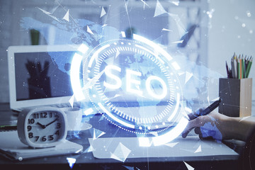 Multi exposure of woman's hands making notes with SEO icon. Concept of Search engine optimization