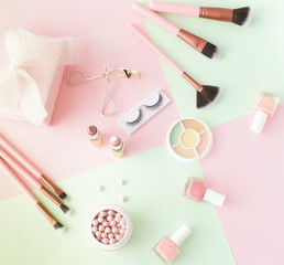 Makeup products, decorative cosmetics on pastel color pink mint background  flat lay.  Fashion and beauty concept. Top view. Copy space