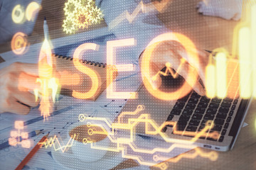 Multi exposure of seo icon with man working on computer on background. Concept of search engine optimization.