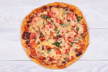 Top view of domestic pizza on white wooden background