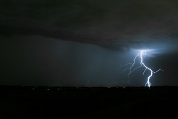 Naklejka na ściany i meble A lightning bolt with many side branches strikes somewhere in the dutch countryside