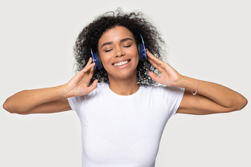 Headshot portrait african woman wearing headphones enjoy favourite music