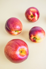Fresh nectarines on a pastel yellow background. The concept of summer fruits, food rich in vitamins, vegetarianism, veganism. 