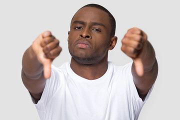 Serious african man showing thumbs down gesture of disapproval