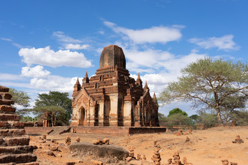 Old Bagan Pagodas in Myanmar with clouds and light blue sky.