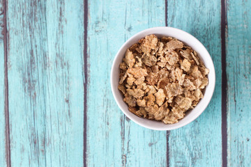 top view of cereals in a white bowl on blue background