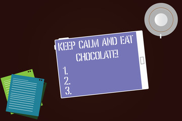 Writing note showing Keep Calm And Eat Chocolate. Business photo showcasing Everything is better when you are eating sweets Tablet Screen Cup Saucer and Filler Sheets on Color Background
