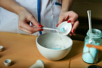 a lab technician conducts chemical experience. the hand of the chemist puts the powder into a bowl. 