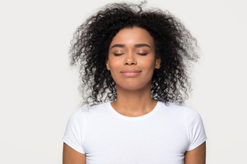 African woman closed eyes dreaming isolated on grey background